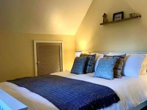 een slaapkamer met een groot bed met blauwe kussens bij 3 bed in Pontdolgoch 90709 in Aberhafesp