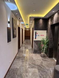 un corridoio di un edificio adibito a uffici con una pianta di Özkaya Otel a Sivas