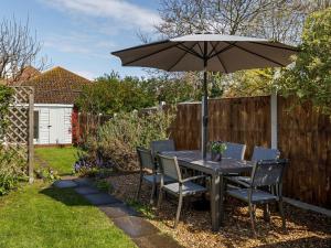 a table and chairs with an umbrella in a backyard at 3 Bed in Sheringham 90701 in Sheringham