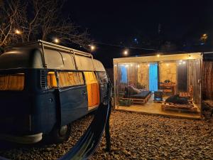 ein blauer Van neben einem Haus mit Schaukel geparkt in der Unterkunft Batroun van camping in Batrun