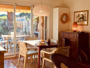 uma cozinha e sala de jantar com mesa e cadeiras em Un jardin en Méditerranée - 2 chambres à 5 min à pied de la plage em La Croix-Valmer