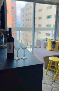 a bottle of wine and two wine glasses on a table at Flat vista mar em Santos in Santos