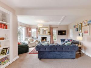 a living room with a blue couch and a fireplace at 3 Bed in Great Malvern 90775 in Mathon