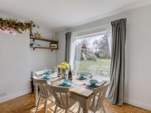 a dining room with a table and chairs and a window at 3 Bed in Great Malvern 90775 in Mathon