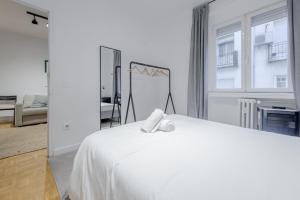 - une chambre avec un lit blanc et un miroir dans l'établissement Centrico Apt para 7pax en La Latina-Centro, à Madrid