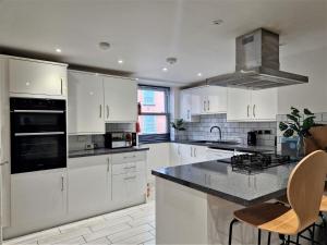 a kitchen with white cabinets and a stove top oven at 2 bed property in Gunnislake Cornwall 90781 in Gunnislake