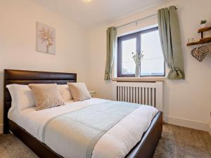 a bedroom with a large bed with a window at 3 Bed in Kington 90768 in Kinnerton