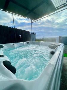a jacuzzi tub with blue water in it at Shepherds hut Greencastle in Omagh
