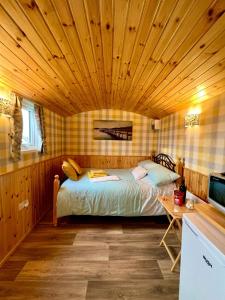 a bedroom with a bed and a wooden ceiling at Shepherds hut Greencastle in Omagh