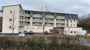 un grand bâtiment avec des voitures garées dans un parking dans l'établissement Apartment 3 ideal für Familien und Geschäftsreisende ABG69, à Gera