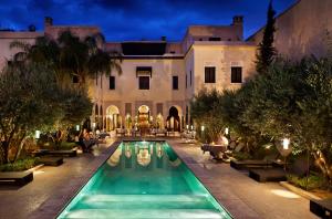 una vista exterior de una mansión con piscina en La Villa des Orangers - Relais & Châteaux en Marrakech