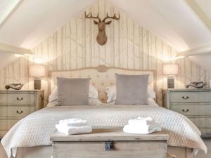 sypialnia z łóżkiem z dwoma komodami i głową jelenia nad nim w obiekcie 2 Bed in County Durham 90576 w mieście Whittonstall