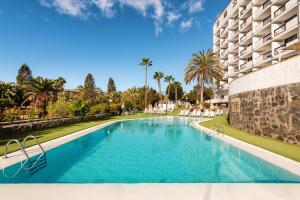 a swimming pool in front of a building at Hotel New Folías in San Agustin