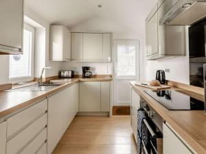 a kitchen with white cabinets and a sink at 3 Bed in Brixham 90565 in Brixham