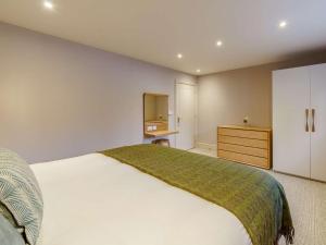 a bedroom with a large white bed and a dresser at 1 Bed in Ambleside 90636 in Ambleside