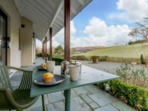 a table with two cups and muffins on it on a patio at 1 Bed in Ambleside 90636 in Ambleside