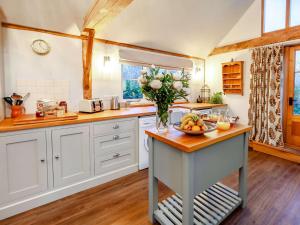 a kitchen with a table with a bowl of fruit on it at 1 Bed in Loxwood 90733 in Loxwood