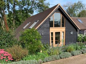 a small black house with windows in a garden at 1 Bed in Loxwood 90733 in Loxwood
