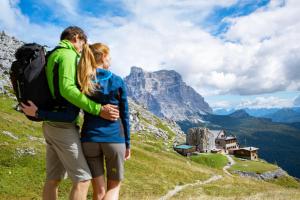 Ein Mann und eine Frau stehen auf einem Berg in der Unterkunft Naturae Lodge in Alleghe