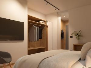 - une chambre avec un lit et une télévision murale dans l'établissement Naturae Lodge, à Alleghe