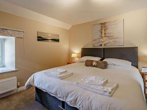 um quarto com uma cama grande e toalhas em 3 Bed in Cosheston 90732 em Cosheston