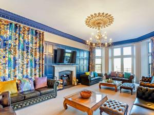 a living room with blue walls and a chandelier at 9 Bed in Porthmadog 90740 in Talsarnau