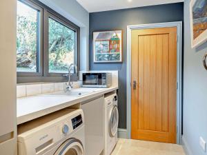 una lavanderia con lavandino e lavatrice di 4 Bed in Bwlch 90596 a Bwlch