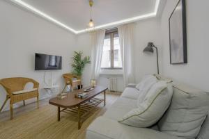 un soggiorno con divano bianco e tavolo di Elegante apartamento en el Centro de Madrid-Rastro a Madrid