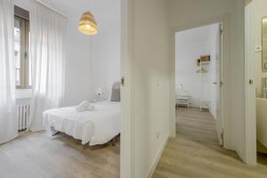 una camera bianca con un letto e un corridoio di Elegante apartamento en el Centro de Madrid-Rastro a Madrid