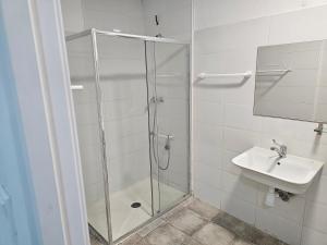 La salle de bains est pourvue d'une douche et d'un lavabo. dans l'établissement MHrosa, à Valence