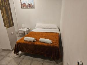 um quarto com uma cama com duas almofadas em MHrosa em Valência