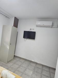 Cette chambre est dotée d'un mur blanc et d'un réfrigérateur. dans l'établissement MHrosa, à Valence