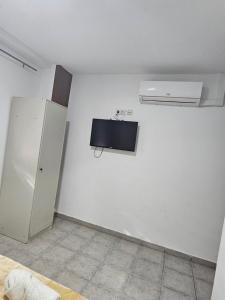 a room with a white wall with a refrigerator at MHrosa in Valencia