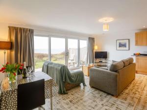 a living room with a couch and a table at 1 Bed in Aberdesach 90624 in Clynnog-fawr