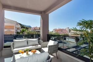 a balcony with two chairs and a table with drinks on it at Villa Bomada in Tučepi