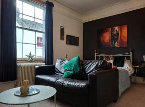 a living room with a leather couch and a table at City Centre Bolt Hole - Exeter in Exeter