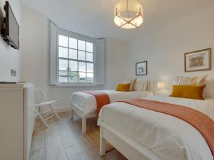 two beds in a white room with a window at 3 Bed in Hawes 90749 in Hawes