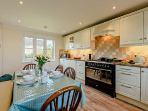 uma cozinha com uma mesa com pratos e flores em 3 Bed in Bembridge 90582 em Bembridge