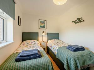 duas camas num pequeno quarto em 3 Bed in Bembridge 90582 em Bembridge