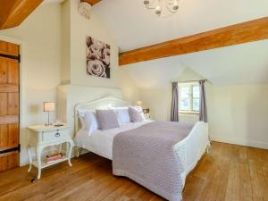 a bedroom with a white bed and a window at 4 Bed in Blakeney 90589 in Awre