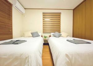 duas camas sentadas uma ao lado da outra num quarto em さくらや旅館 em Mongawa