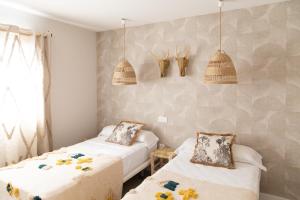 a bedroom with two beds and two baskets on the wall at Ereza White Homes in Caleta De Fuste