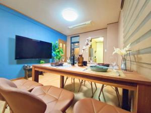 uma sala de jantar com uma mesa de madeira e cadeiras em さくらや旅館 em Mongawa