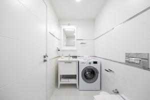 une salle de bains blanche pourvue d'un lave-linge. dans l'établissement Stella Stays Istanbul Etiler, à Istanbul