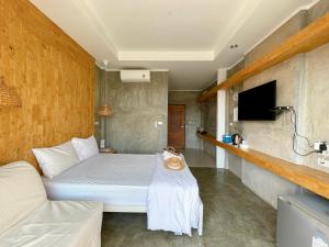 ラン島にあるCheck-in Resort Koh Larnのベッドとテレビ付きのホテルルーム