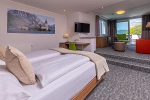 グムンデンにあるSeehotel im Weyerの大型ベッドとテレビが備わるホテルルームです。