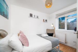 1 dormitorio con cama y ventana en Madika Homes - Cosy Edgware 2 Bed Flat with Free parking, en Edgware