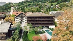 a large building with a swimming pool in a village at Posthotel Taube in Schruns