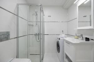een witte badkamer met een douche en een wasmachine bij Stella Stays Istanbul Etiler in Istanbul