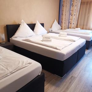 2 camas en una habitación de hotel con sábanas blancas en Hotel Hasselberg, en Kaiserslautern